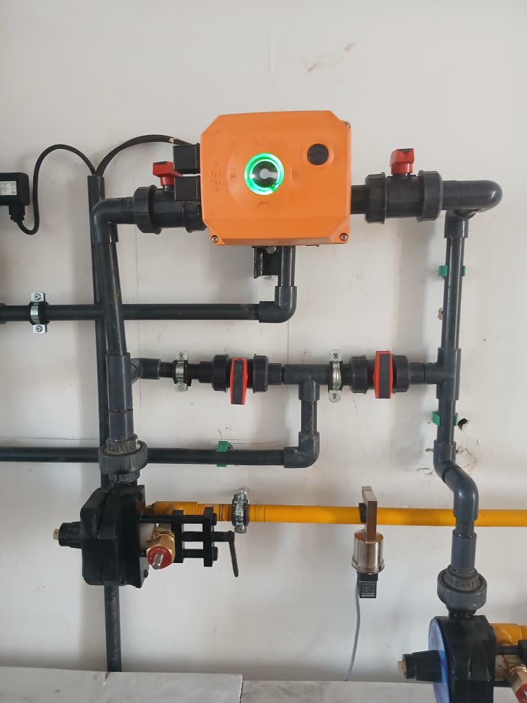 Closeup of orange actuator control valve on laboratory service piping