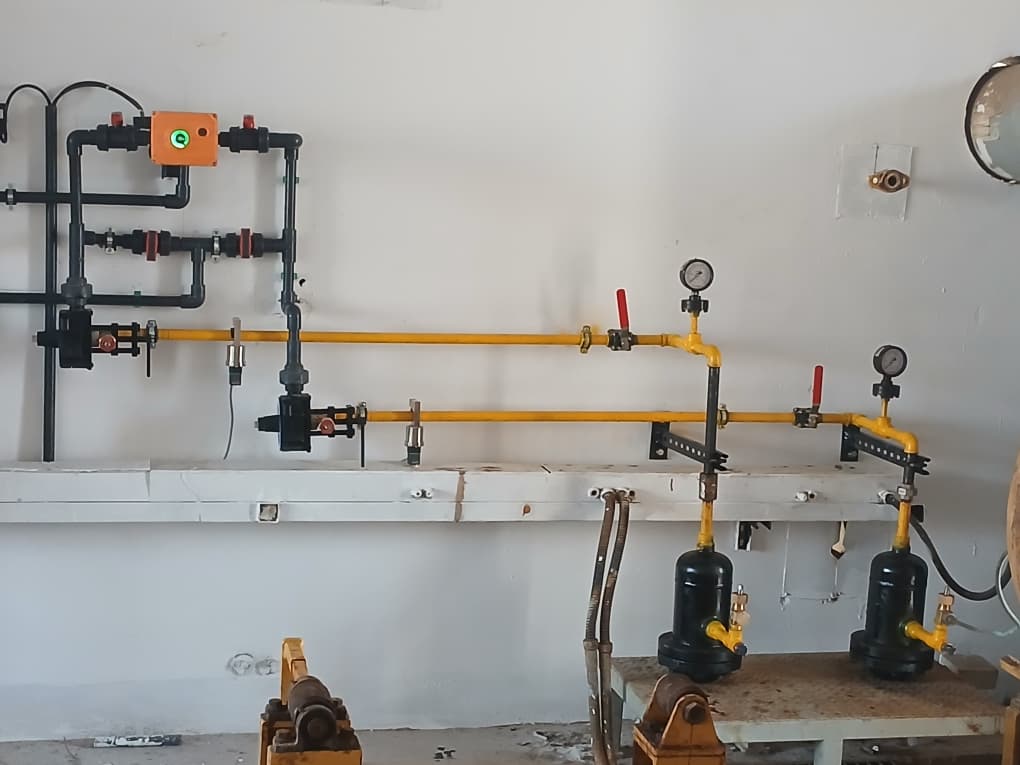 Yellow laboratory gas lines with pressure gauge stations and service cylinders